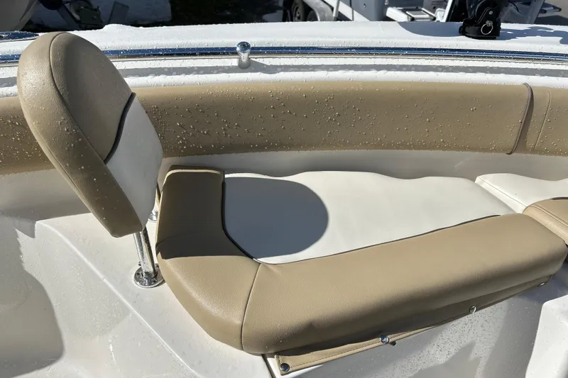 Slide: The Image of 2019 Key West 239 FS boat seat with beige and white upholstery, wet from water droplets. - 11