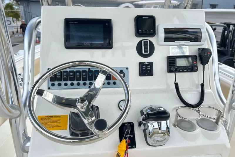 Slide: The Image of 2019 Key West 239 FS boat dashboard with steering wheel, controls, and navigation equipment. - 4