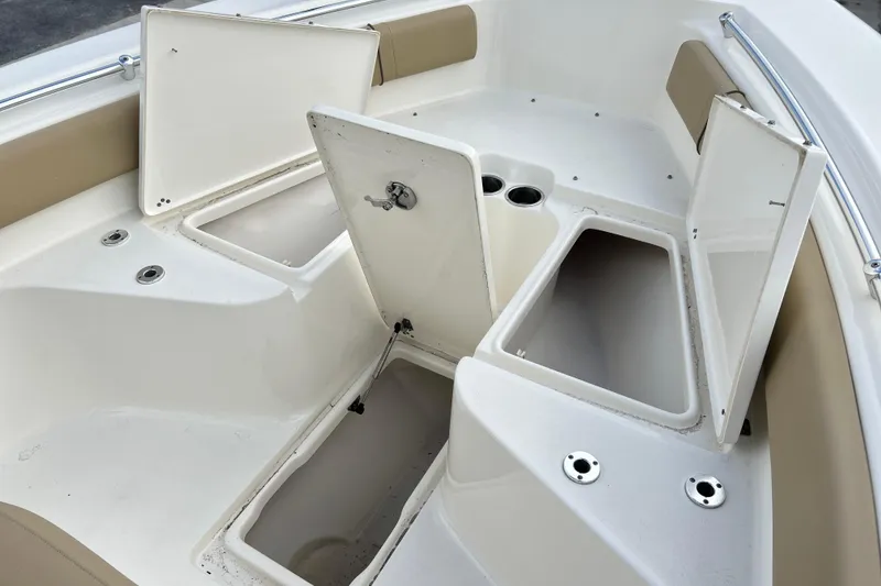 Slide: The Image of 2019 Key West 239 FS boat interior with open storage compartments and cup holders. - 6