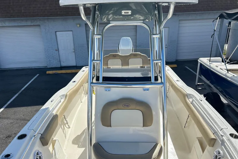Slide: The Image of 2019 Key West 239 FS boat interior with seating and console, parked outdoors. - 8