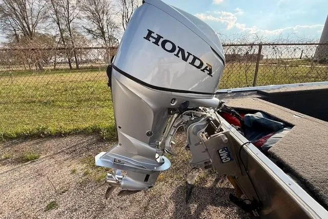 Slide: The Image of Silver Honda outboard motor on a 2022 Rhino V Pro Stick boat, parked outdoors. - 5