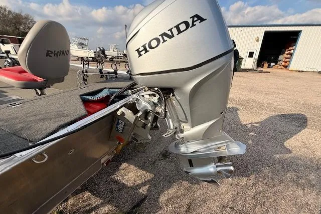 Slide: The Image of Boat with Honda outboard motor and Rhino V Pro Stick seat, 2022 model, in a marina setting. - 8