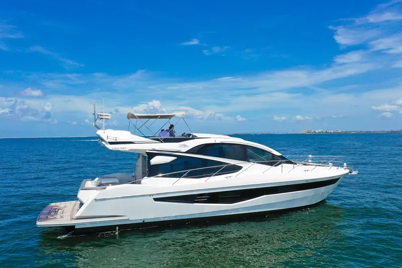 Slide: The Image of 2019 Galeon 560 Sky yacht cruising on open water under clear blue skies. - 2