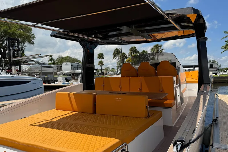 Slide: The Image of 2024 Tesoro T40 luxury boat with orange seating, docked under a sunny sky. - 18