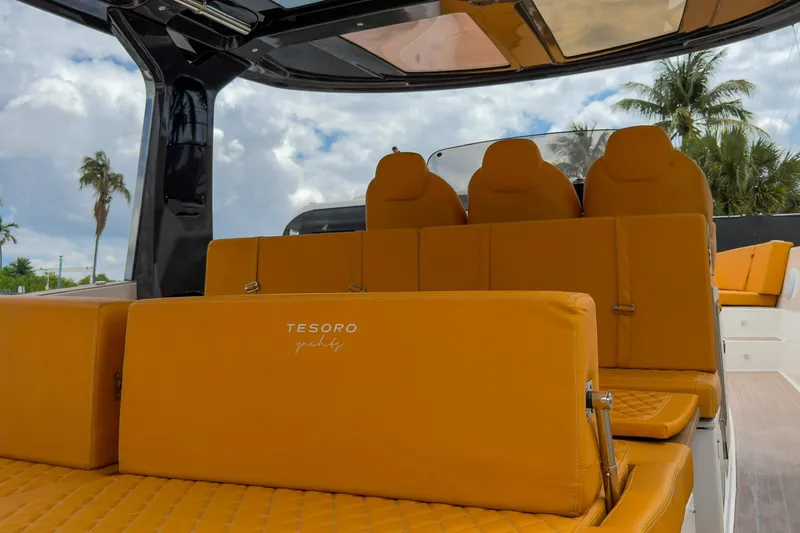 Slide: The Image of Luxurious orange seating on 2024 Tesoro T40 yacht, with palm trees and sky in the background. - 28