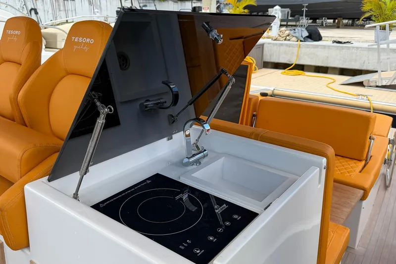 Slide: The Image of 2024 Tesoro T40 yacht interior with orange seating, sink, and induction cooktop. - 31
