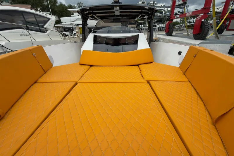 Slide: The Image of 2024 Tesoro T40 boat with vibrant orange quilted seating, docked at a marina. - 43