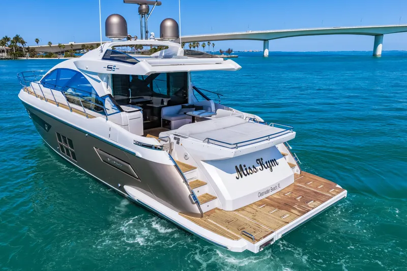 Slide: The Image of Luxury 2020 Azimut S6 yacht cruising in clear blue waters near a bridge. - 19