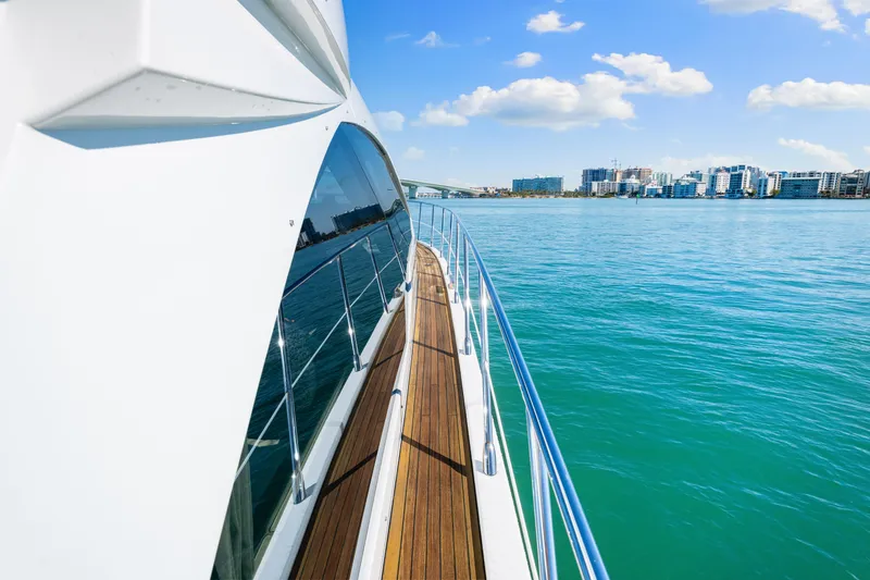 Slide: The Image of 2020 Azimut S6 yacht cruising on clear blue waters near a city skyline. - 89