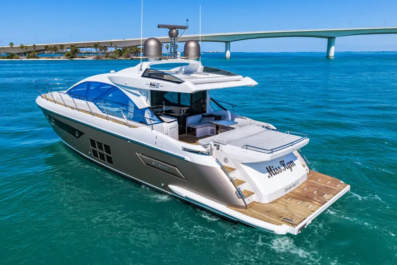 Slide: The Image of Luxury 2020 Azimut S6 yacht cruising in clear blue waters near a scenic bridge. - 16