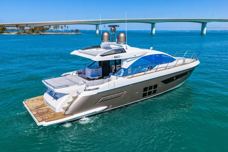 Slide: The Image of Luxury 2020 Azimut S6 yacht cruising on clear blue waters near a bridge. - 33
