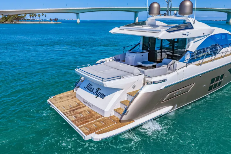 Slide: The Image of Luxury 2020 Azimut S6 yacht cruising in clear blue waters near a bridge. - 36