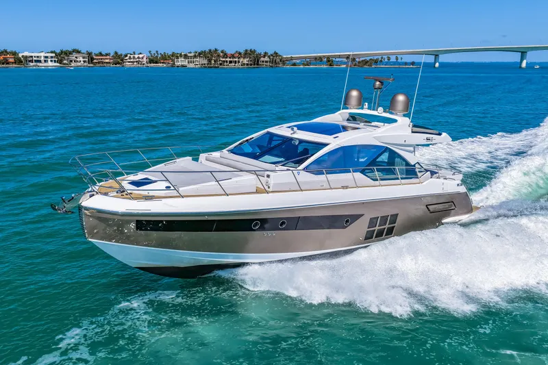 Slide: The Image of 2020 Azimut S6 yacht cruising on blue ocean near coastal homes and bridge. - 43