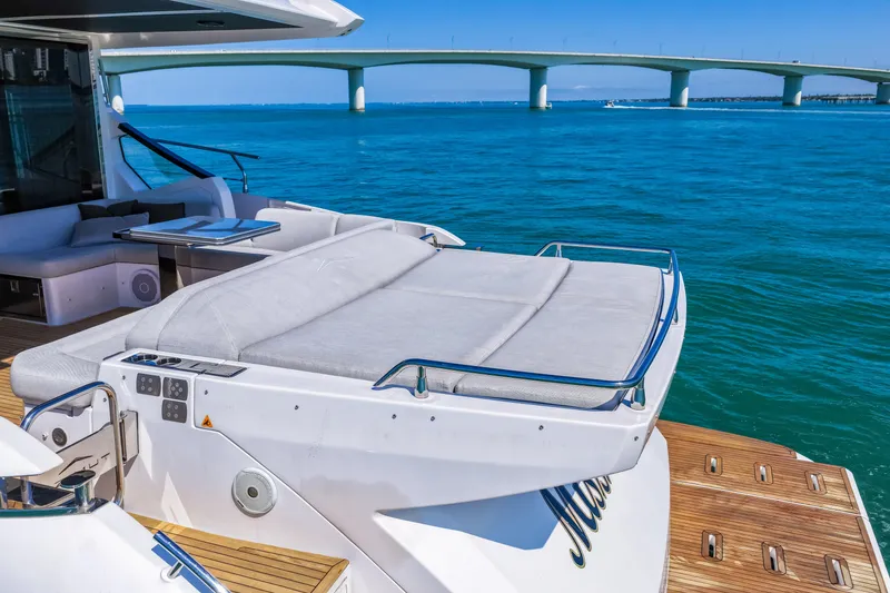 Slide: The Image of Luxurious 2020 Azimut S6 yacht with sunbed, overlooking serene blue waters and a bridge. - 22