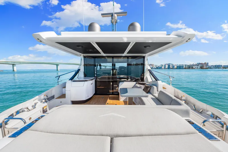 Slide: The Image of Luxurious 2020 Azimut S6 yacht deck with modern seating, overlooking serene blue waters and cityscape. - 80