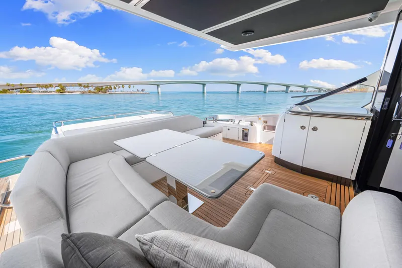 Slide: The Image of Luxurious 2020 Azimut S6 yacht deck with elegant seating, overlooking serene blue waters and a bridge. - 83