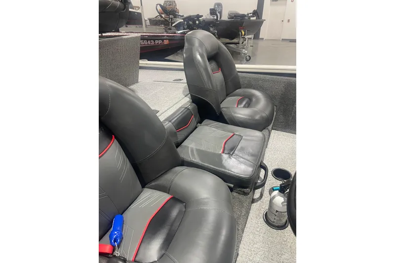 Slide: The Image of 2024 Tracker Pro Team 175 TXW boat interior with black and red seats. - 40