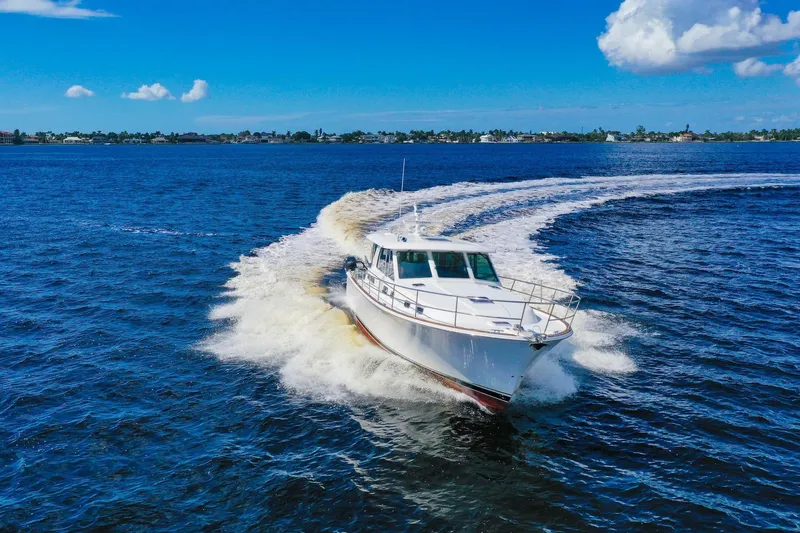 Slide: The Image of 2019 Sabre 45 Salon Express cruising on open water under a clear blue sky. - 100