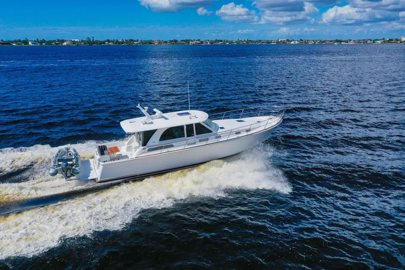 Slide: The Image of 2019 Sabre 45 Salon Express yacht cruising on open water under blue skies. - 101
