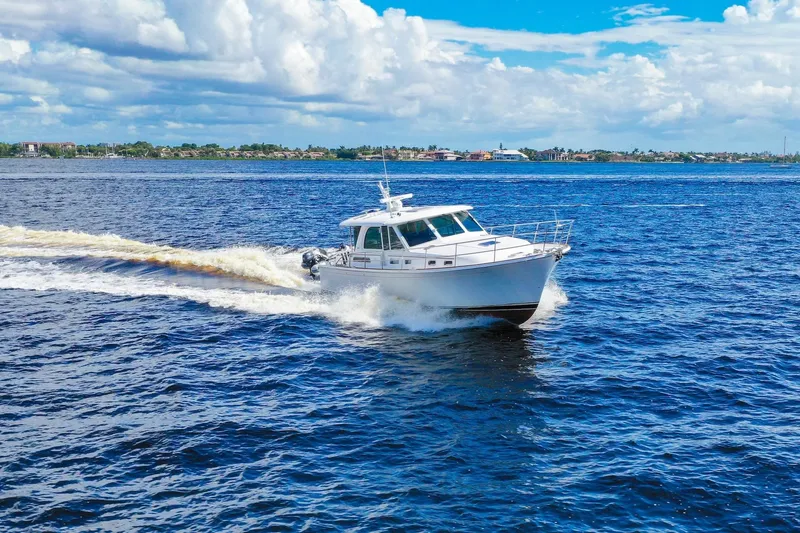 Slide: The Image of 2019 Sabre 45 Salon Express cruising on open blue waters under a partly cloudy sky. - 103