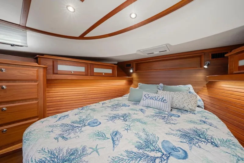 Slide: The Image of Luxurious 2019 Sabre 45 Salon Express bedroom with nautical-themed bedding and elegant wood paneling. - 25