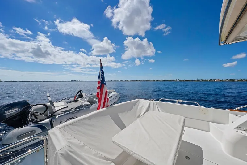 Slide: The Image of 2019 Sabre 45 Salon Express yacht with American flag, ocean view, and clear blue sky. - 54