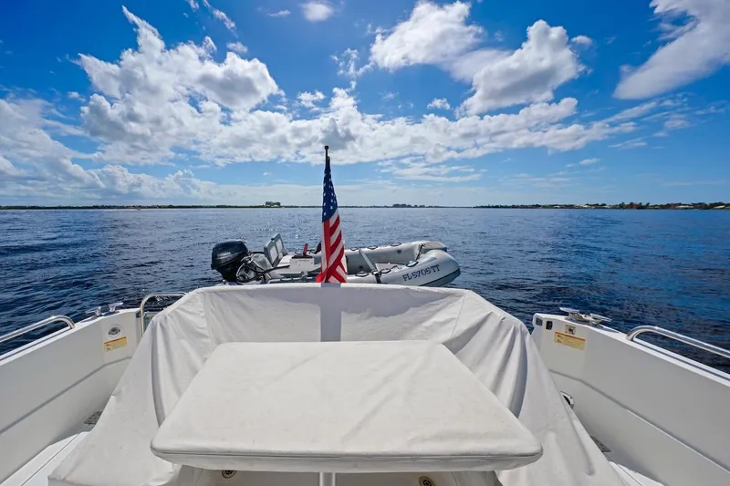 Slide: The Image of 2019 Sabre 45 Salon Express yacht with American flag, ocean view, and inflatable boat. - 55