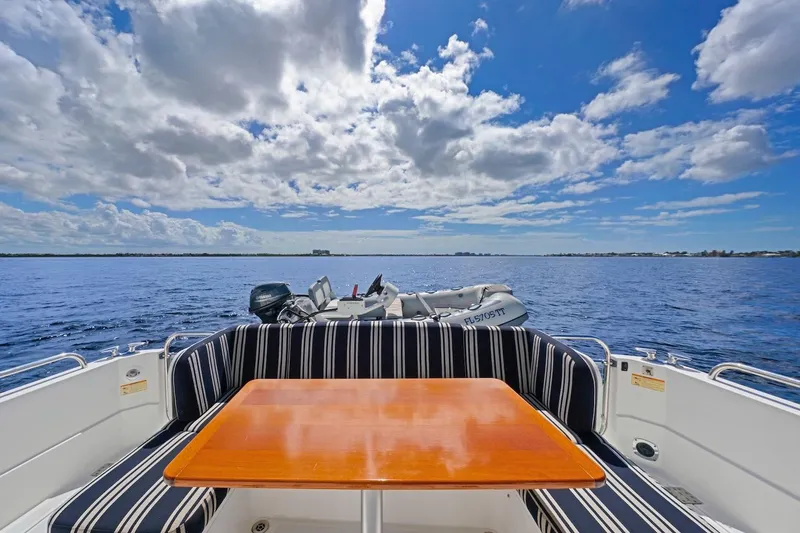Slide: The Image of 2019 Sabre 45 Salon Express yacht with striped seating, wooden table, and ocean view. - 58