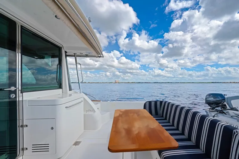 Slide: The Image of 2019 Sabre 45 Salon Express yacht with striped seating, wooden table, and ocean view. - 60