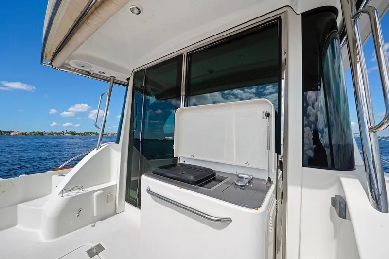 Slide: The Image of 2019 Sabre 45 Salon Express yacht deck with grill, overlooking serene blue waters. - 64