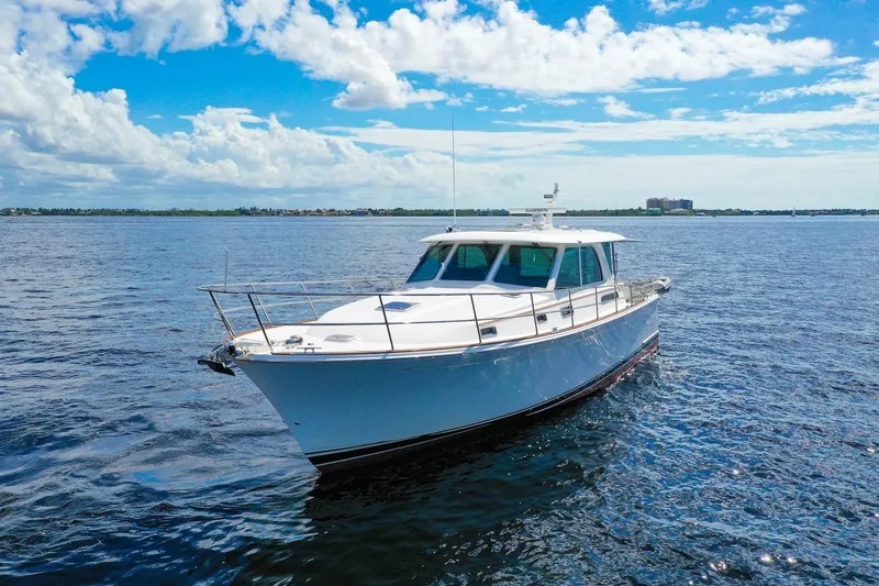 Slide: The Image of 2019 Sabre 45 Salon Express yacht cruising on open water under a clear blue sky. - 73