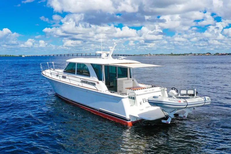 Slide: The Image of 2019 Sabre 45 Salon Express yacht cruising on open water under a cloudy sky. - 76