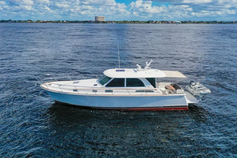 Slide: The Image of 2019 Sabre 45 Salon Express yacht cruising on open water under a partly cloudy sky. - 84