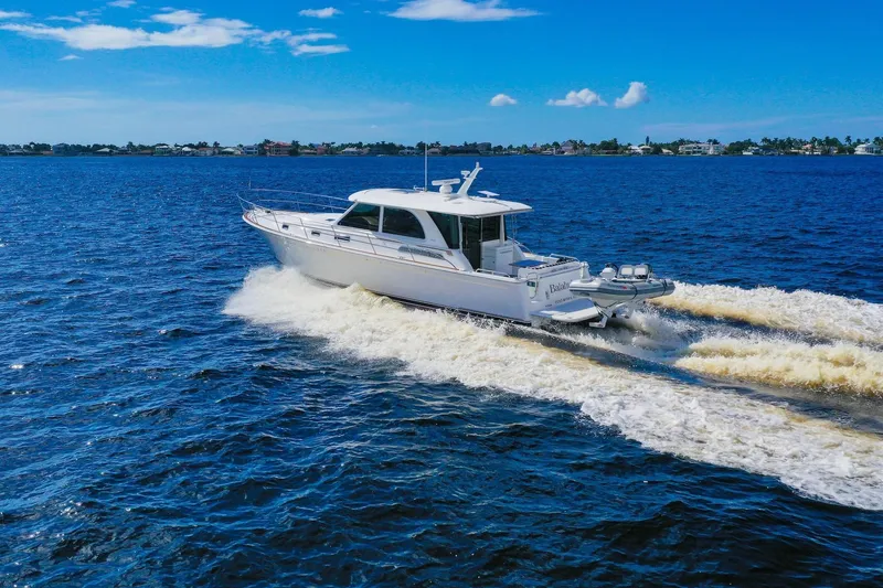 Slide: The Image of 2019 Sabre 45 Salon Express cruising on open water under a clear blue sky. - 98