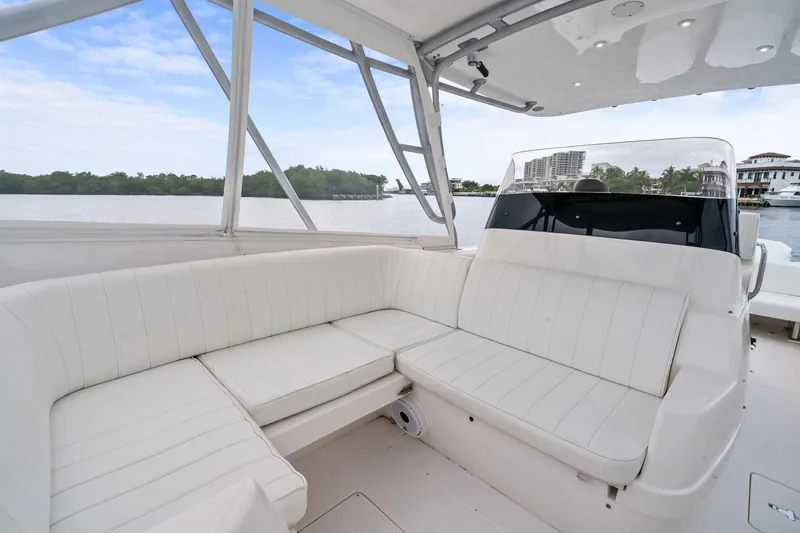 Slide: The Image of 2011 Intrepid 370 Cuddy boat interior with white seating and waterfront view. - 13