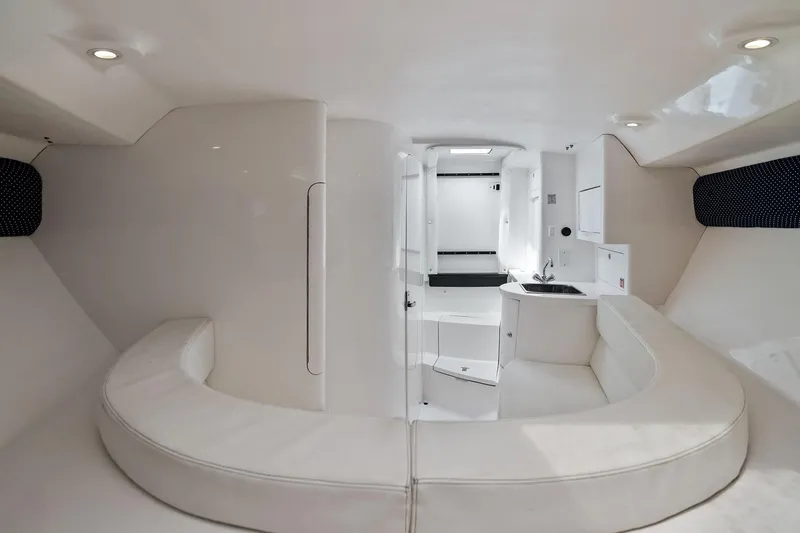 Slide: The Image of Interior of 2011 Intrepid 370 Cuddy boat, featuring sleek white seating and compact kitchenette. - 15