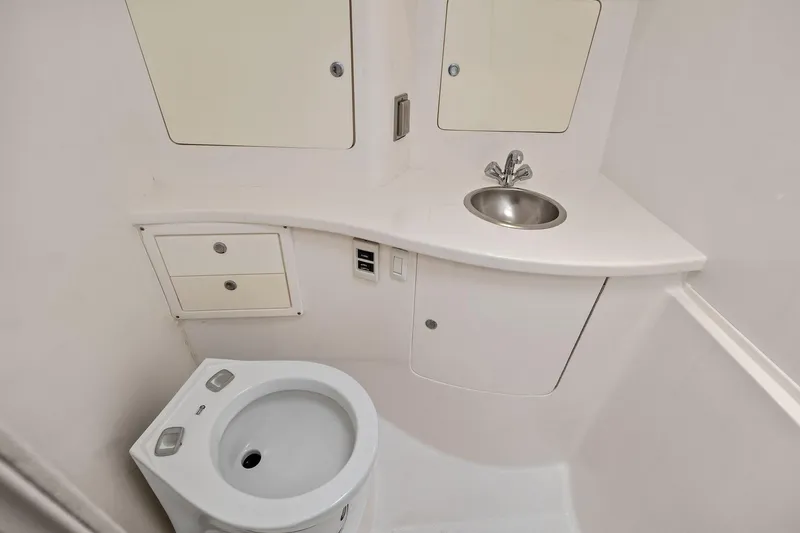 Slide: The Image of 2011 Intrepid 370 Cuddy bathroom with sink, toilet, and storage cabinets. - 19
