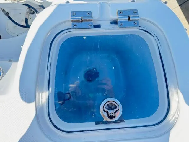 Slide: The Image of Livewell on a 2016 Boston Whaler 350 Outrage boat, featuring a clear lid and blue interior. - 11