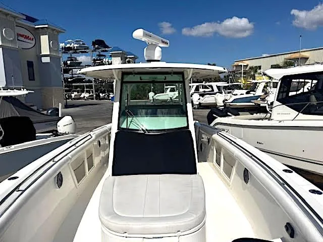 Slide: The Image of 2016 Boston Whaler 350 Outrage boat docked at a marina under a clear sky. - 2