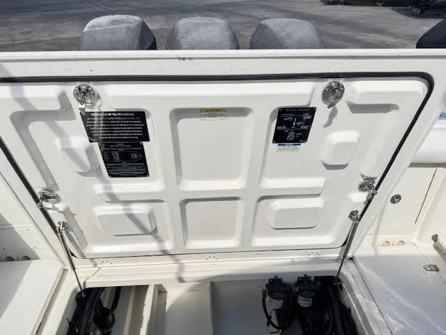 Slide: The Image of 2016 Boston Whaler 350 Outrage engine compartment with open hatch, showing mechanical components. - 30