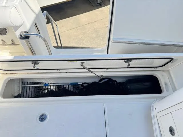 Slide: The Image of 2016 Boston Whaler 350 Outrage storage compartment with open lid, showcasing interior space. - 35