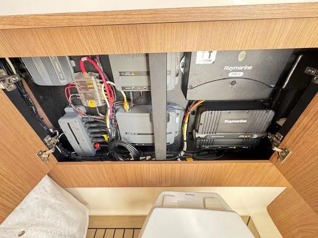 Slide: The Image of 2016 Boston Whaler 350 Outrage electronics compartment with Raymarine equipment and wiring. - 43