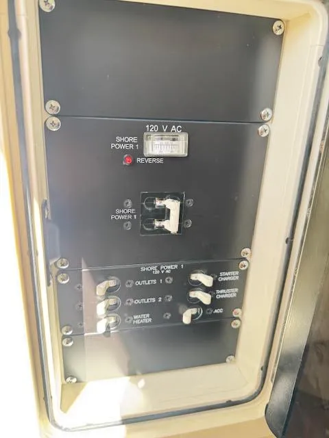 Slide: The Image of Electrical panel on a 2016 Boston Whaler 350 Outrage boat, showing shore power controls. - 45