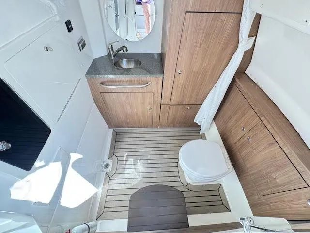 Slide: The Image of 2016 Boston Whaler 350 Outrage boat bathroom with wood accents and modern fixtures. - 5