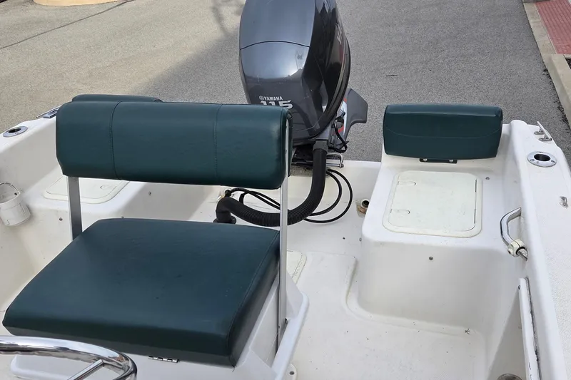 Slide: The Image of 2011 Cobia 194 Center Console boat interior with Yamaha 115 engine, featuring green seating. - 4