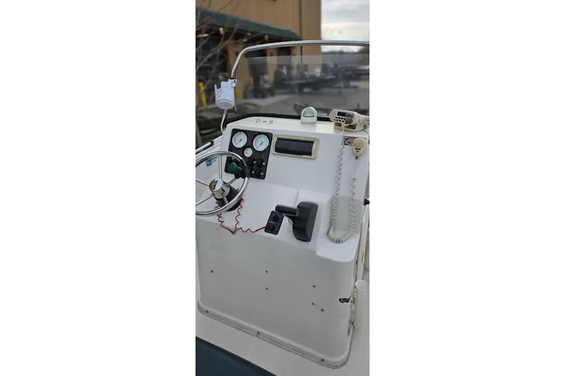 Slide: The Image of 2011 Cobia 194 Center Console boat dashboard with steering wheel and controls. - 5