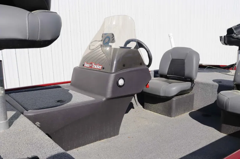 Slide: The Image of 2023 Tracker 17 BassCLSXL boat console and seating outdoors. - 8