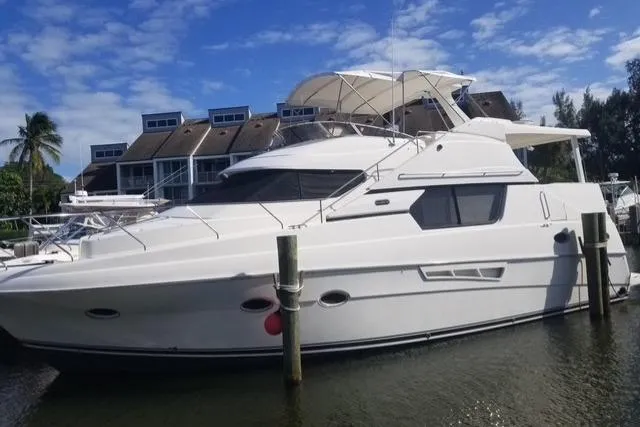 The Image of 2000 Silverton 453 Pilothouse Motor Yacht docked by waterfront homes. - 0