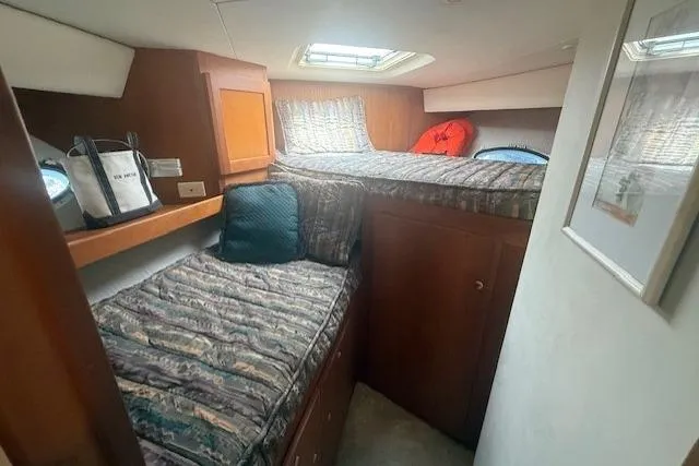 Slide: The Image of 2000 Silverton 453 Pilothouse Motor Yacht cabin with twin beds and wooden cabinetry. - 2