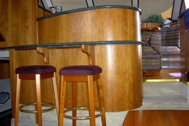 Slide: The Image of Interior of 2000 Silverton 453 Pilothouse Motor Yacht with wooden bar and stools. - 5